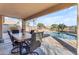 Relaxing patio with wooden table, chairs, and a view of the pool at 22821 S 212Th St, Queen Creek, AZ 85142