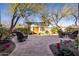 Charming backyard patio with brick pavers, mature trees, and comfortable outdoor seating areas at 33296 N Vanishing Trl, Scottsdale, AZ 85266