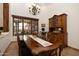 Formal dining room featuring an elegant chandelier, large window, and antique furnishings at 33296 N Vanishing Trl, Scottsdale, AZ 85266