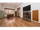 Bright open living area with hardwood floors, a stone fireplace, and shuttered windows at 33296 N Vanishing Trl, Scottsdale, AZ 85266