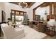 Cozy living room featuring an ornate wooden beam, high ceilings, a decorative chandelier, and comfortable furniture at 33296 N Vanishing Trl, Scottsdale, AZ 85266