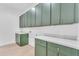 Well-lit laundry room with green cabinets and ample counter space at 433 W Saddle Mountain Road --, Phoenix, AZ 85086