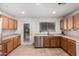Well-lit kitchen featuring stainless steel appliances, wood cabinets, and tile flooring at 2083 S 155Th Ln, Goodyear, AZ 85338