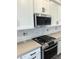 Modern kitchen featuring stainless steel appliances, white cabinets, and stylish backsplash at 43513 N Wollemi St, Queen Creek, AZ 85140