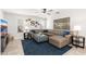 Spacious living room with plush leather sofa, stylish ottoman, ceiling fan, and an abundance of natural light at 4660 E Torrey Pines Ln, Chandler, AZ 85249