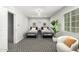 Shared bedroom with two beds, a comfortable chair, natural lighting and patterned carpeting at 735 E Calavar Rd, Phoenix, AZ 85022