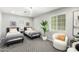 Comfortable bedroom showcasing twin beds, white accent chair, and a lush potted plant at 735 E Calavar Rd, Phoenix, AZ 85022
