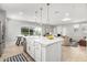 Modern kitchen island with white countertop, farmhouse sink, pendant lighting, and adjacent dining area at 735 E Calavar Rd, Phoenix, AZ 85022