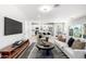 Modern living room with hardwood floors, open floor plan, white sofa, and large flat screen TV at 735 E Calavar Rd, Phoenix, AZ 85022