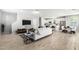 Bright, stylish living room featuring a modern white sofa, open layout, and hardwood-style flooring at 735 E Calavar Rd, Phoenix, AZ 85022