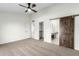 Spacious bedroom with carpet, ceiling fan, barn door, and en-suite bathroom at 4340 E Nisbet Rd, Phoenix, AZ 85032