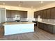 Bright kitchen features a spacious island, stainless steel appliances and modern cabinetry at 43499 N Wollemi St, Queen Creek, AZ 85140