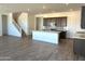 Open-concept kitchen and living room with wood flooring and a large center island at 43499 N Wollemi St, Queen Creek, AZ 85140