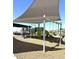 Fun playground area covered with shade, featuring swings, slides, and climbing structures at 43499 N Wollemi St, Queen Creek, AZ 85140