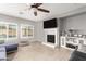 Cozy living room featuring a fireplace with TV, plantation shutters, and ceiling fan at 9982 W Villa Chula --, Peoria, AZ 85383