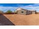 Large and level dirt backyard with a block wall and view of the home's exterior at 12337 W Marguerite Ave, Avondale, AZ 85323