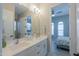 Spacious bathroom featuring double sinks and a large mirror, with bedroom in background at 18169 W Cactus Flower W Dr, Goodyear, AZ 85338