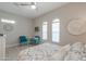 Well-lit bedroom features accent chairs, ceiling fan, and bright decor at 18169 W Cactus Flower W Dr, Goodyear, AZ 85338