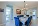 Elegantly set dining room featuring a modern chandelier, stylish blue chairs, and bright, neutral decor at 18169 W Cactus Flower W Dr, Goodyear, AZ 85338