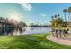 Serene lake view with a bench, lush grass, and palm trees at 1825 W Ray Rd # 2060, Chandler, AZ 85224