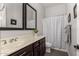 Clean bathroom with dark wood vanity, striped shower curtain, and large mirror at 20404 W Crescent Dr, Buckeye, AZ 85396