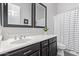 Clean bathroom with single vanity, striped shower curtain, and dark wood cabinets at 20404 W Crescent Dr, Buckeye, AZ 85396