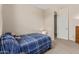 Cozy bedroom with neutral carpet, a blue plaid bedspread and ample closet space at 2837 W Minton St, Phoenix, AZ 85041