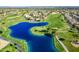 Overhead view of a blue lake on a golf course surrounded by palm trees and green fairways at 3721 N 150Th Ct, Goodyear, AZ 85395