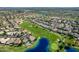 Aerial view of a community on a golf course with lush green fairways, and lake views at 3721 N 150Th Ct, Goodyear, AZ 85395