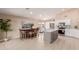 Modern kitchen featuring stainless steel appliances, a gray island, and a dining area with a wooden table at 3721 N 150Th Ct, Goodyear, AZ 85395