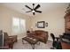 Bright home office with a comfortable couch, built in desk, and ceiling fan at 6217 E Sienna Bouquet Pl, Cave Creek, AZ 85331