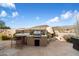 Outdoor kitchen featuring a grill and fireplace at 9784 E Miramonte Dr, Scottsdale, AZ 85262