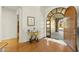 Inviting entryway features hardwood floors, a unique glass table, and an arched doorway leading to the outside at 2 E Biltmore Estates Dr # 115, Phoenix, AZ 85016