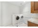 Well-lit laundry room with a washer, dryer, and storage cabinets at 2 E Biltmore Estates Dr # 115, Phoenix, AZ 85016