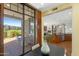 Bright dining room with a patio view, hardwood floors, and a clear sightline to the living room and kitchen at 2 E Biltmore Estates Dr # 115, Phoenix, AZ 85016