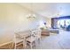 Open-concept dining area connects to a living room with outdoor access and modern lighting at 3800 S Cantabria Cir # 1023, Chandler, AZ 85248