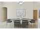 Dining room with a modern table, gray chairs, chandelier, and arched doorway, adjacent to the entryway at 8146 E Wingspan Way, Scottsdale, AZ 85255