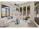 Living room with travertine floors, a ceiling fan and multiple windows overlooking the backyard and pool at 8146 E Wingspan Way, Scottsdale, AZ 85255