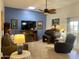 Inviting living room with blue walls, large television, roll top desk, and a comfortable seating area at 11012 W Thunderbird W Blvd, Sun City, AZ 85351