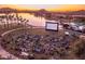 Community movie night on the lawn, surrounded by a lake, palm trees, and mountain views at 15312 S 181St Dr, Goodyear, AZ 85338