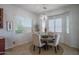 Bright dining area with a round wood table, upholstered chairs, bay windows, and decorative chandelier at 15312 S 181St Dr, Goodyear, AZ 85338