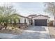 Charming home featuring a gray garage door, desert landscaping, and a mix of stone and stucco finishes at 15312 S 181St Dr, Goodyear, AZ 85338