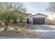 Charming single-Gathering home featuring a two-car garage, landscaped front yard, and stone accents at 15312 S 181St Dr, Goodyear, AZ 85338
