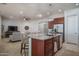 Open kitchen with a granite island, stainless steel appliances, seating, and an adjacent living area at 15312 S 181St Dr, Goodyear, AZ 85338