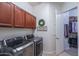 Well-equipped laundry room boasts upper cabinets, modern machines, and convenient access to a closet at 15312 S 181St Dr, Goodyear, AZ 85338