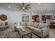 Spacious living room featuring a comfortable sectional sofa, modern ceiling fan, and open access to the kitchen at 15312 S 181St Dr, Goodyear, AZ 85338