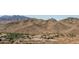 Scenic aerial view of desert landscape with mountains and a building with a parking lot in the foreground at 15312 S 181St Dr, Goodyear, AZ 85338