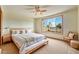 Bright bedroom with a large window, light colored walls, ceiling fan, a comfy bed and light wood floors at 29007 N 120Th Dr, Peoria, AZ 85383