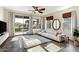 Bright living room featuring a ceiling fan, light sofa, large windows and sliding glass door access to the outdoor area at 29007 N 120Th Dr, Peoria, AZ 85383