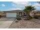 Single-story home with a two-car garage and desert landscaping at 17475 W Caribbean Ln, Surprise, AZ 85388
